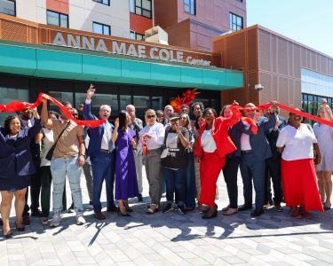 Mayor Wu joins Mildred Hailey residents cutting the ribbon in front of the new Anna Mae Cole Center in Jamaica Plain. Photo by TCB